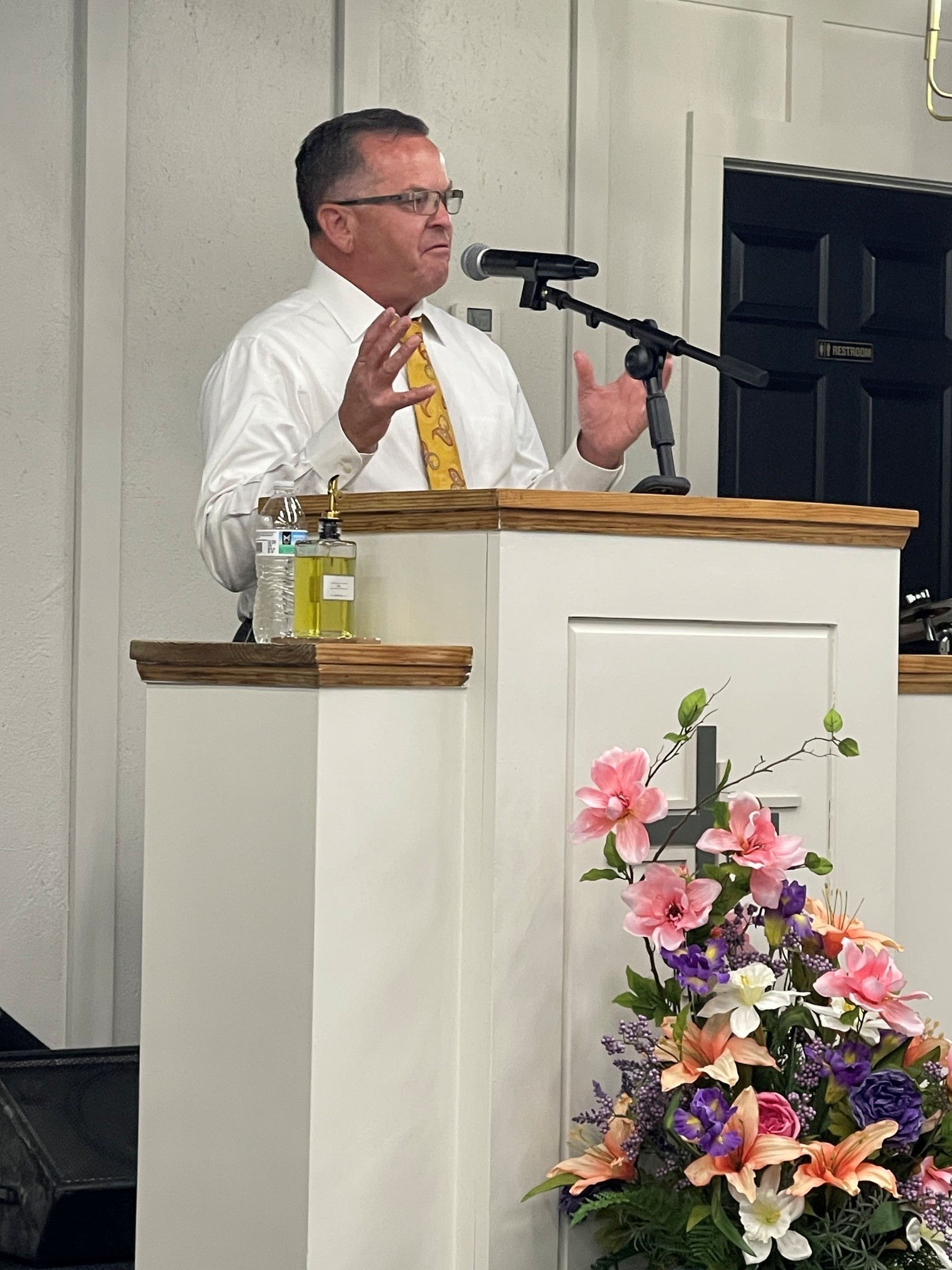 Minister preaching near the altar flowers